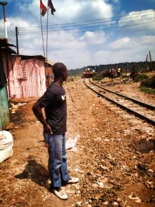 One of our guides standing along the railway which runs through the middle of Kibera.